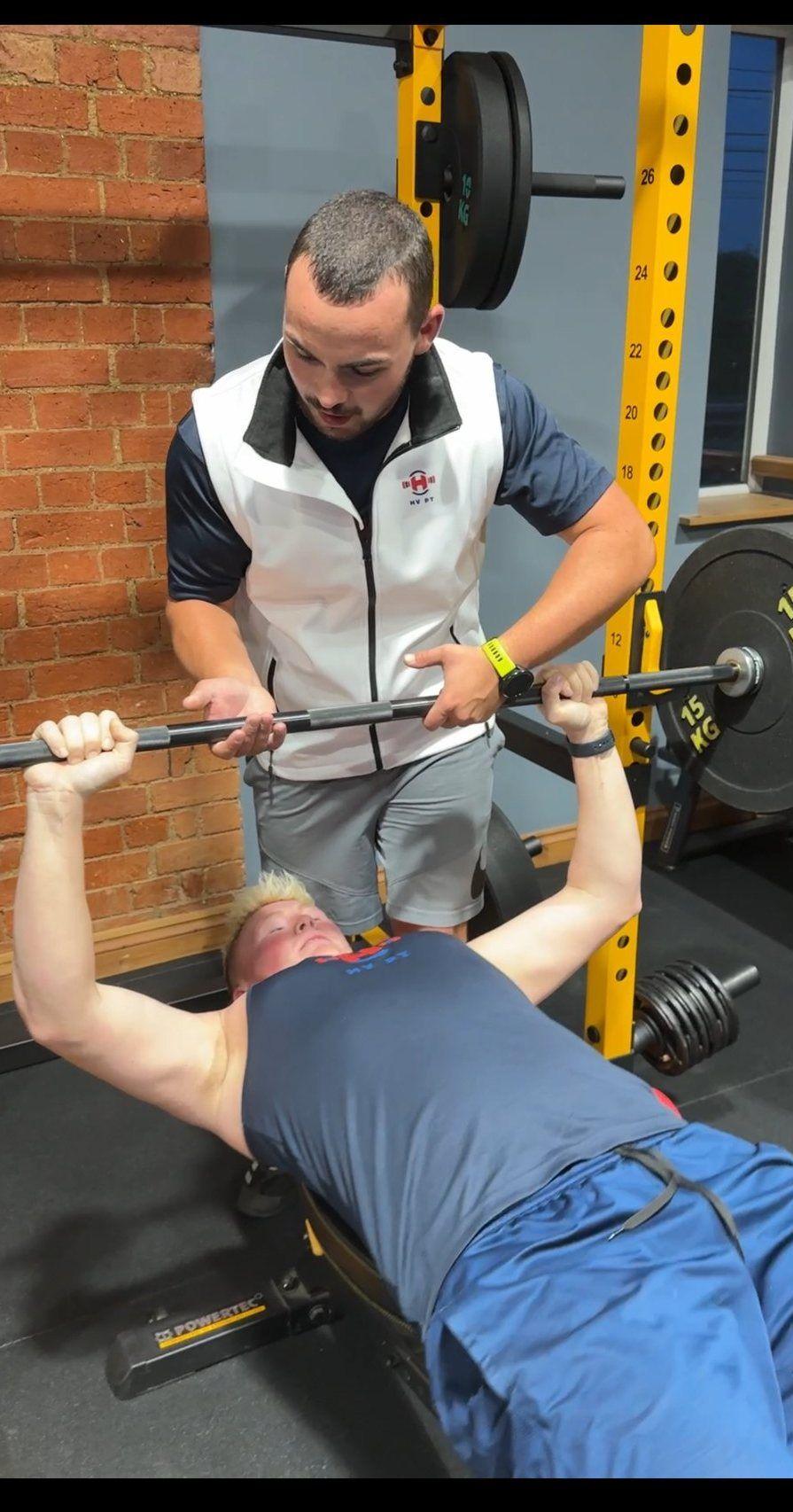 Harry coaching a member through a bench press