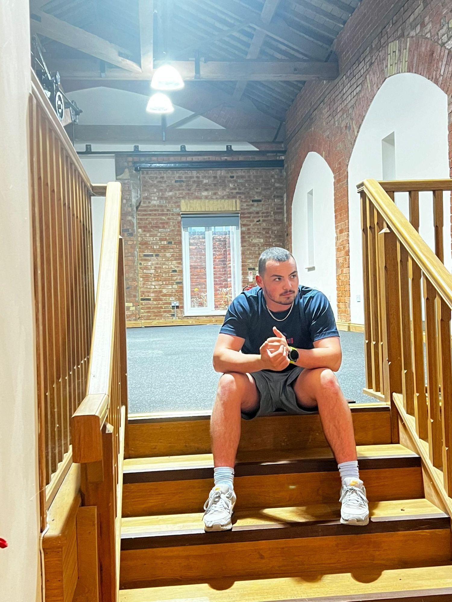 Harry Vine sitting on the stairs at The Engine Shed
