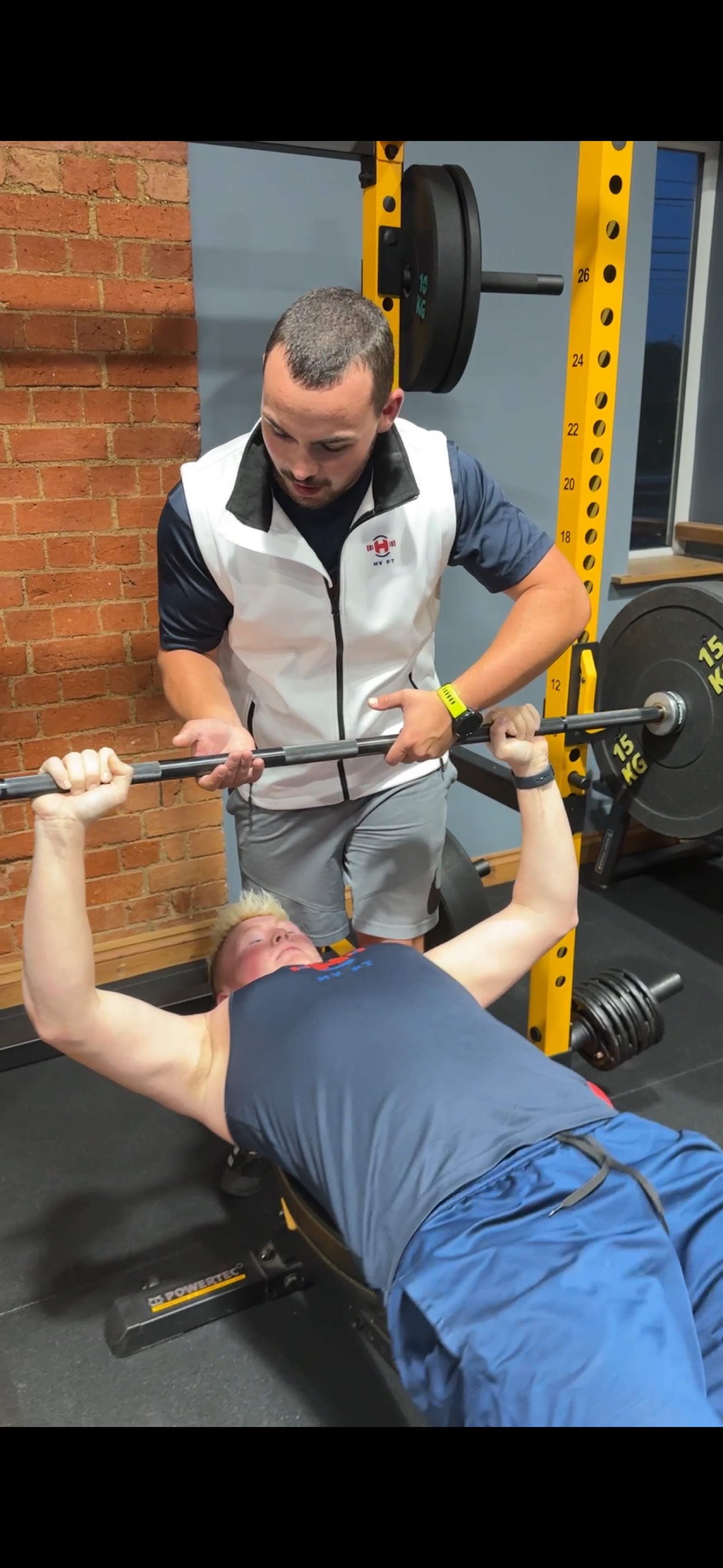 Harry coaching a member through a bench press