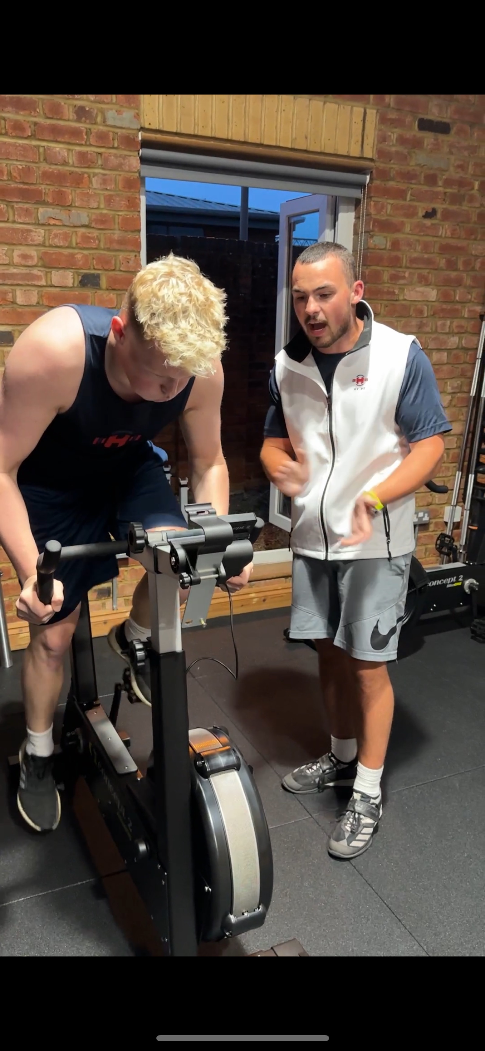 Harry coaching a member on the rowing machine